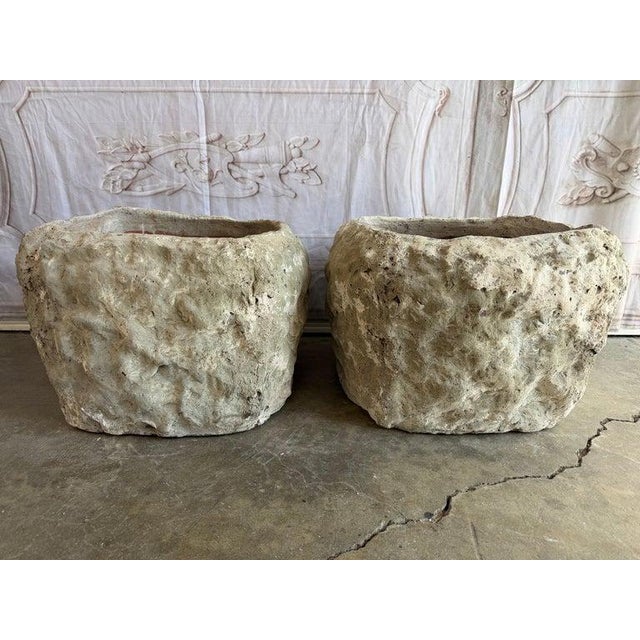 A remarkable pair of terra cotta planters each exhibiting a bold, organic form shaped by both craftsmanship and time....