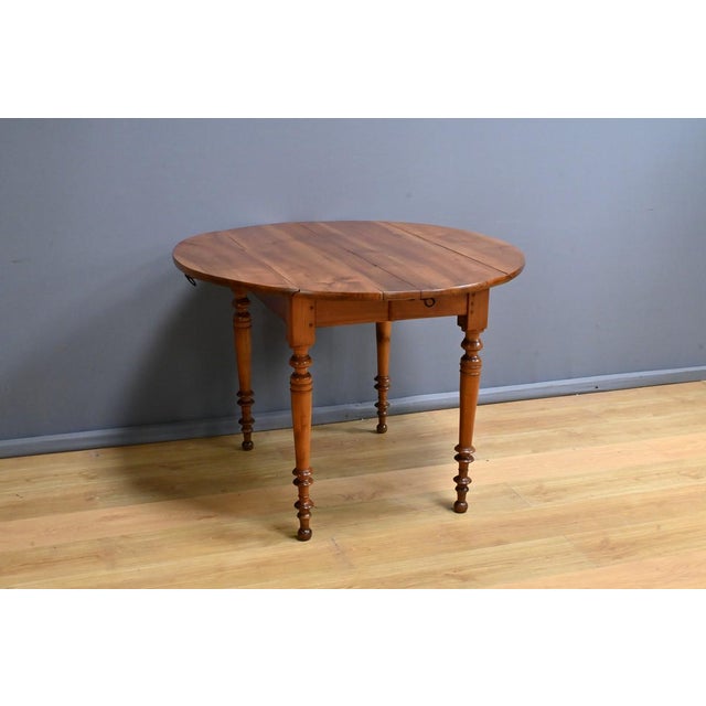 This Louis Philippe-style cherrywood extending table is a true testament to the craftsmanship of the late 19th century....