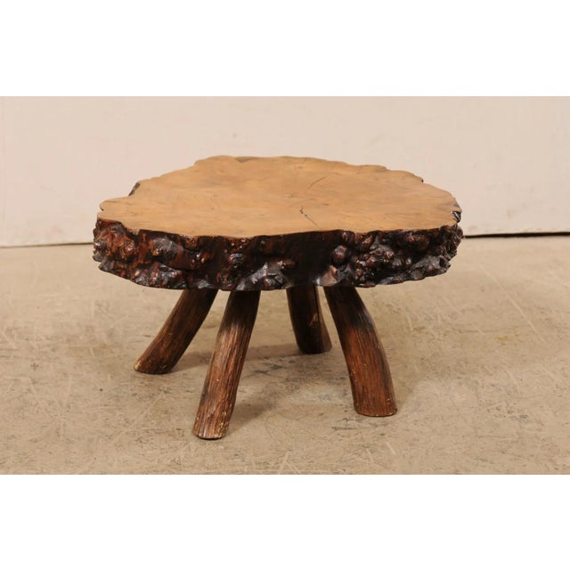 An early 20th century Spanish burl wood slab top coffee table. This antique smaller-size table from Spain features a thick...