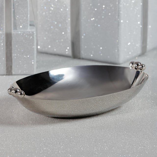 Elegant yet understated, this polished metal oval bowl brings a touch of modern refinement to your table or countertop....