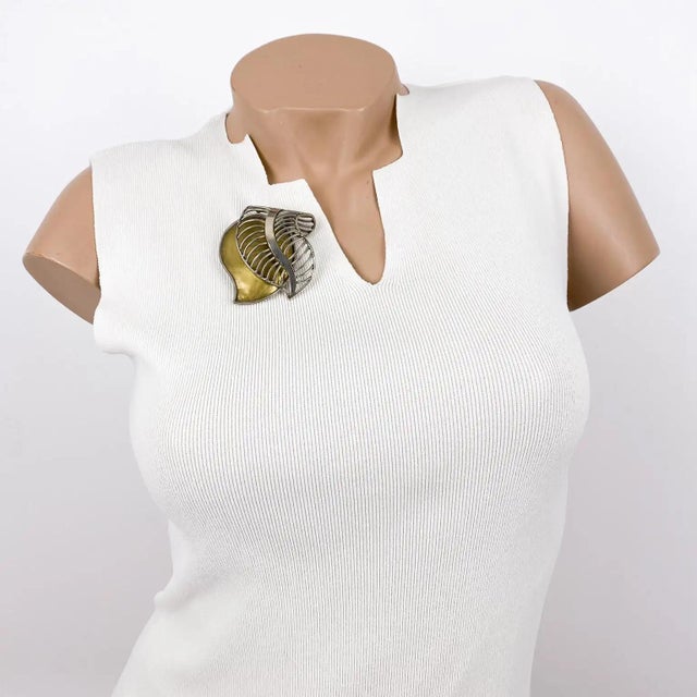 Fabrice, Paris designed this elegant floral brooch. The rare piece features a brass and chrome leaf design with...