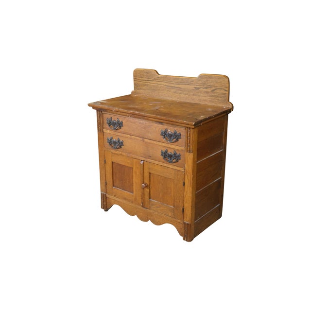 Antique American late-Victorian oak washstand. Features a rectangular top surface crowned by a stylized, stepped wooden...