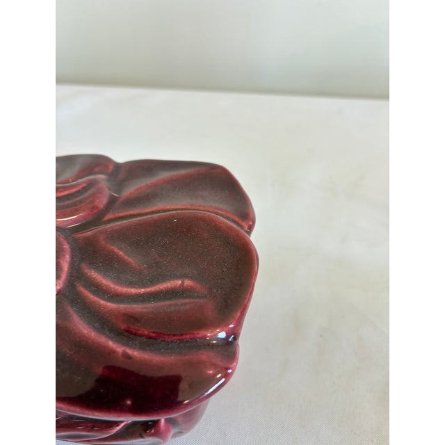 A 1950s ceramic lidded box by Claire Lerner, California, featuring a sculptural raised floral lid and flowing botanical...