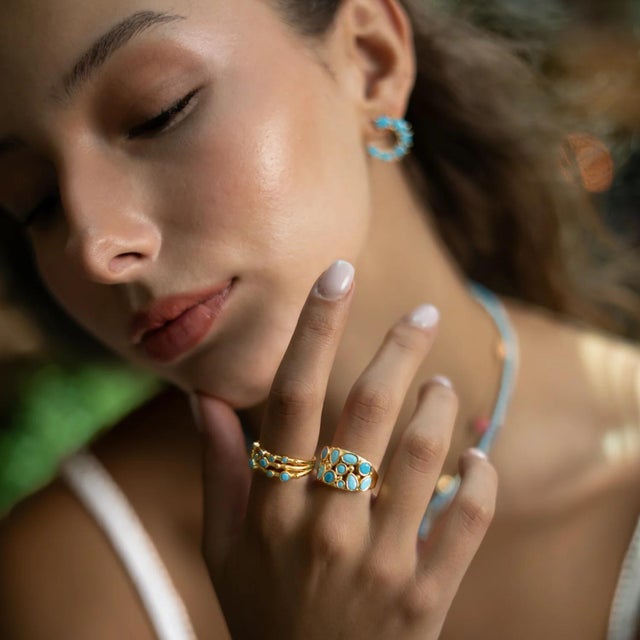 Bring a touch of timeless elegance and protective energy to your look with the Turquoise Dream Gold Adjustable Ring. The...