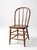 A vintage Windsor-style chair featuring the classic spindle-back silhouette and a solid wood seat with beautiful natural...