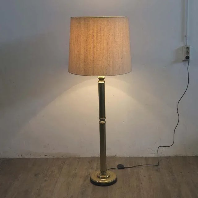 This large brass floor lamp was manufactured in 1960-1970. It features a heavy base and a fabric shade. European Plug (up...