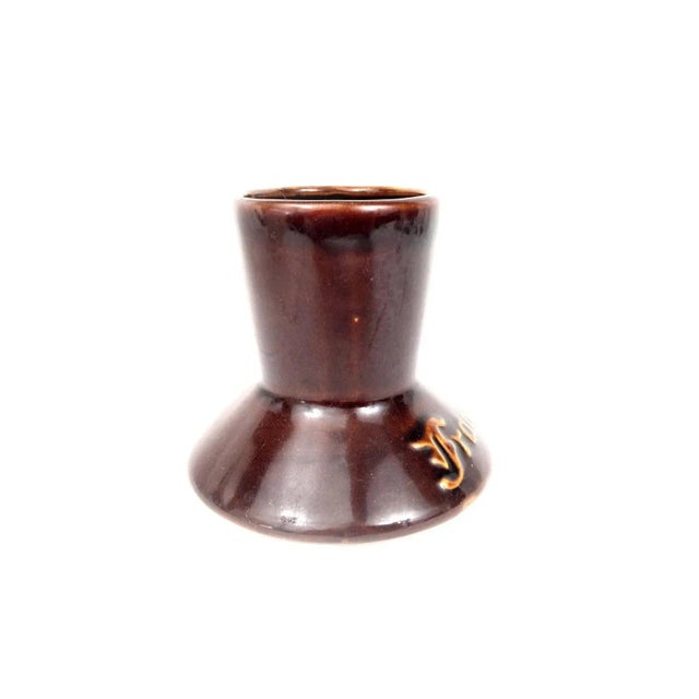 This Frangelico mug is a collectible glazed ceramic stein featuring a unique design with a handle and footed base. This...