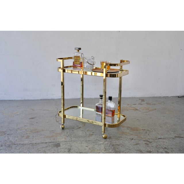 mid-century modern brass and glass bar cart, widely attributed to designer Milo Baughman for Thayer Coggin. Produced...