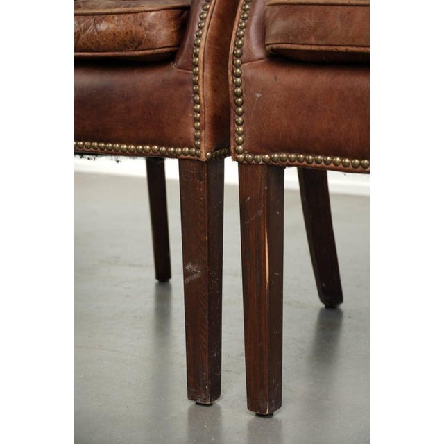 This set of 2 versatile cognac-colored English-style cowhide leather occasional chairs/desk chairs is finished with...