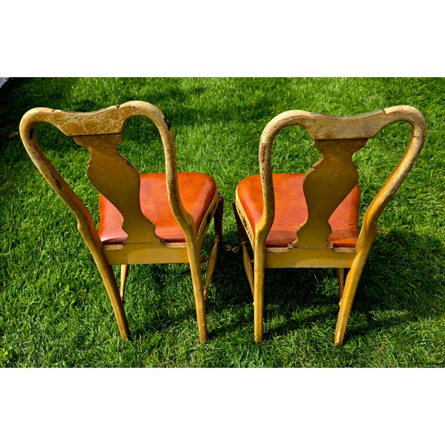 A pair of yellow, hand-painted side chairs in the Chinoiserie or Japanned style, featuring curved splat backs with pagoda...