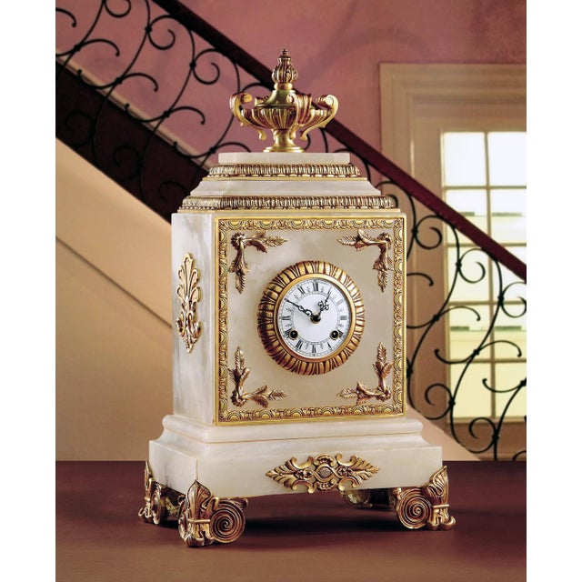 This regal mantle clock is crafted from luminous white alabaster and adorned with intricately cast bronze ormolu, finished...