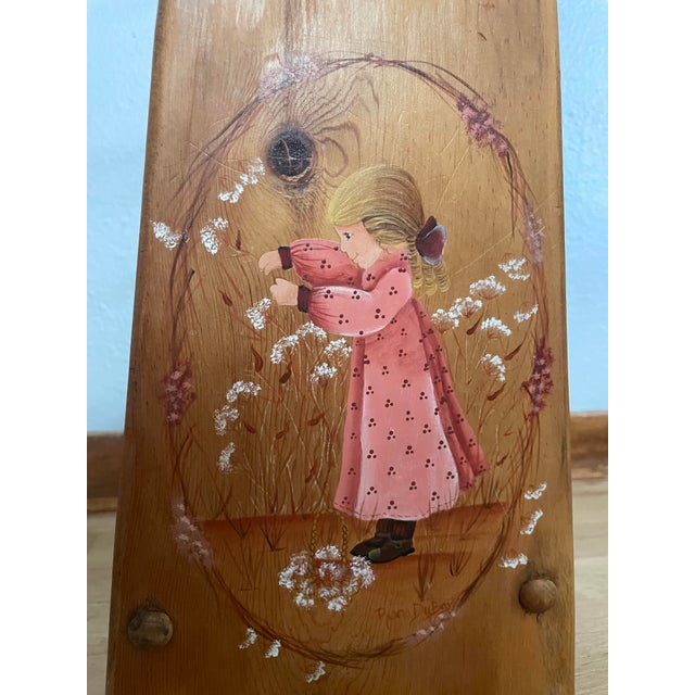 A beautiful vintage wooden quilt rack with hand-painted accents of a woman picking flowers. In addition to hanging linens,...