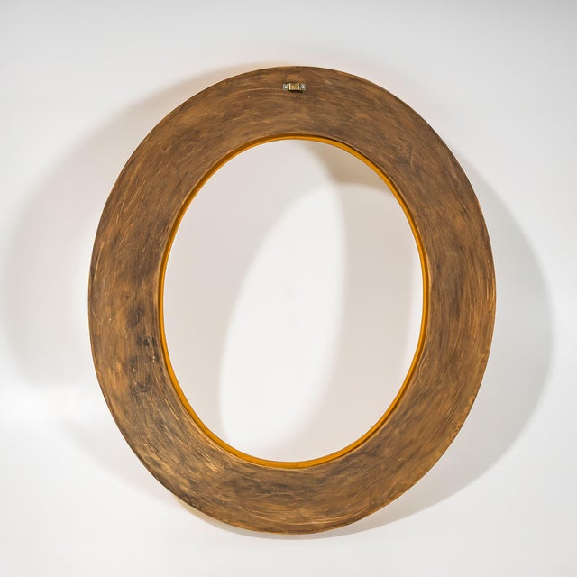 Oval giltwood frame with delicate floral decorations, a cyma molding, and a laurel wreath motif. The multi-profiled...