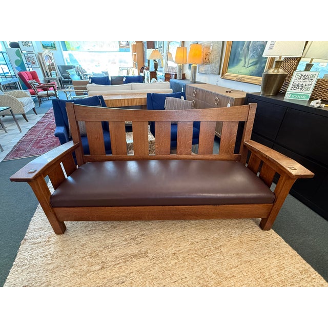 Design Plus Gallery presents a Drop Arm Settee by L & JG Stickley. This is a vintage to antique aged piece that has tiger...