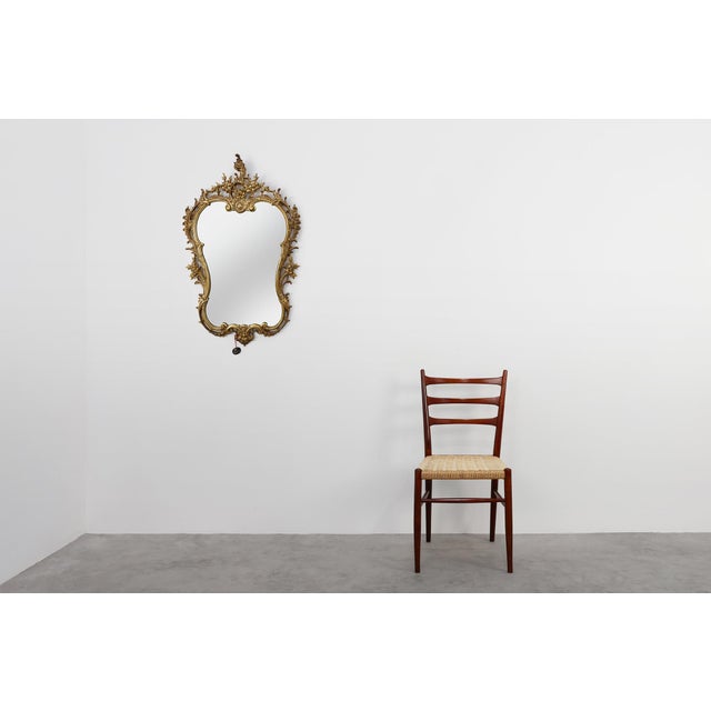 An exuberant French wall mirror from the 1950s, crafted in gilt metal and richly ornamented in the Louis XVI tradition...