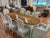 A graceful French Provincial dining set centered on a large oval table with a rich, warmly figured wood top featuring...