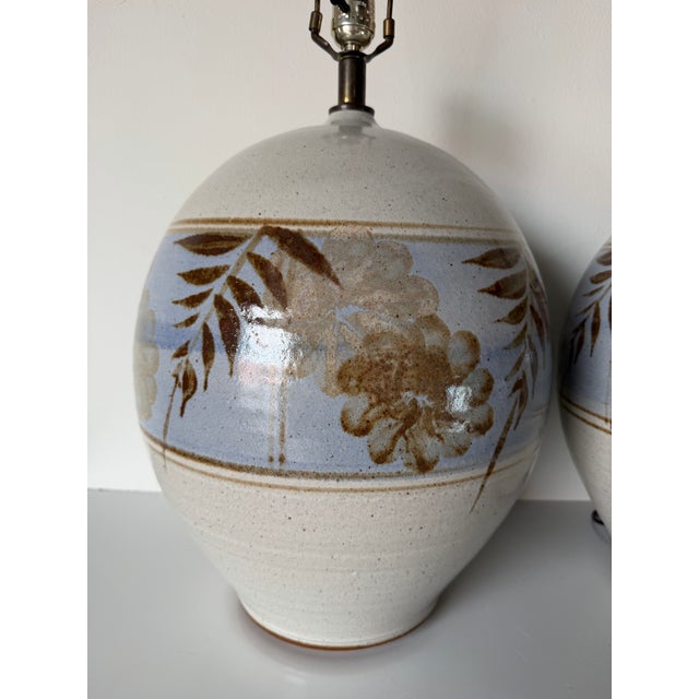 A beautiful pair of vintage Mid-Century California studio pottery table lamps featuring generously proportioned spherical...