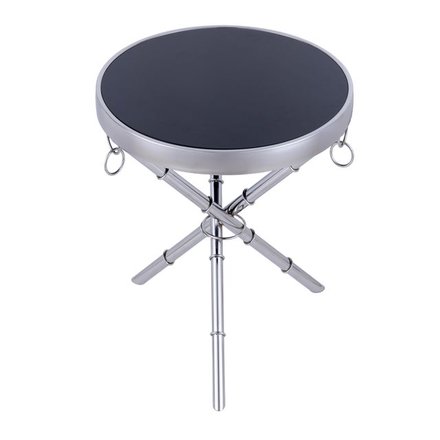 The Eloise Side Table features black tempered glass atop a gold-plated stainless steel frame, with ring details and subtly...