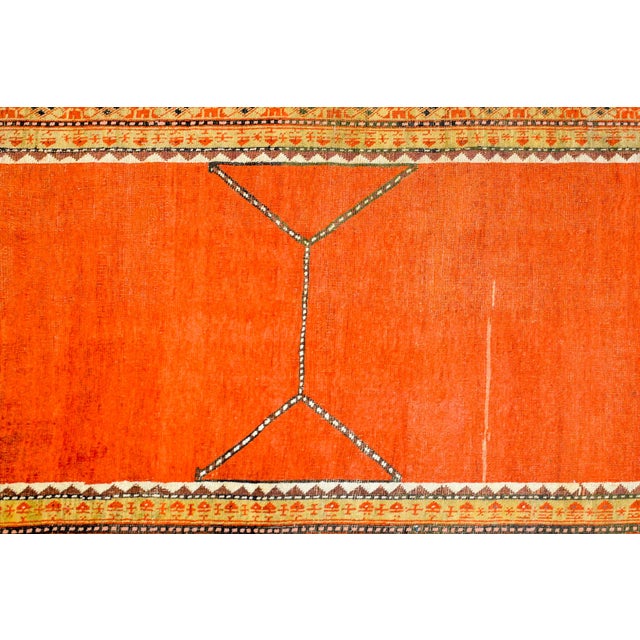 A stunning 1920s Turkish Konya rug with a bold abrash orange field with a simple line pattern across the centre,...