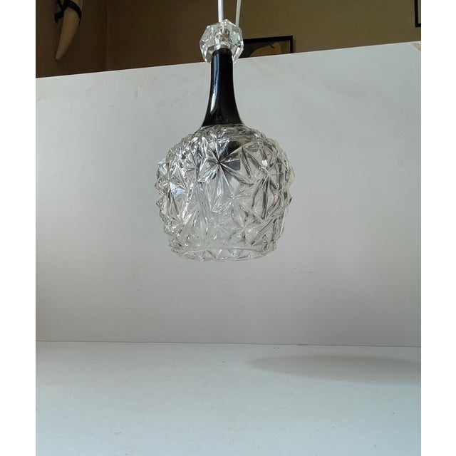 A small German or Scandinavian Diablo shaped pendant light composed of a pressed glass shade in a black metal top upon...