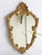 Small baroque style mirror made in Italy. The mirror has a beautiful carved golden frame. It has ornaments all over and is...