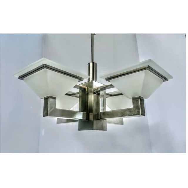 Early 21st century postmodern Mission style chandelier in brushed nickel finish with frosted-glass shades. Has four arms...