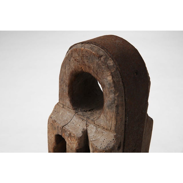 A striking relic of early 20th‑century maritime industry, this large double wooden pulley block embodies the rugged...