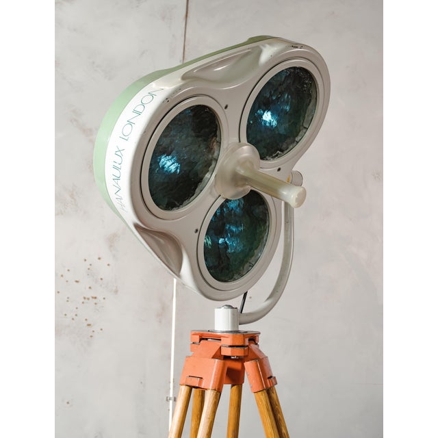 A 1990s heraeus hanaulux london shadowless surgical lamp, reworked into a floor lamp and mounted on a wooden surveying...