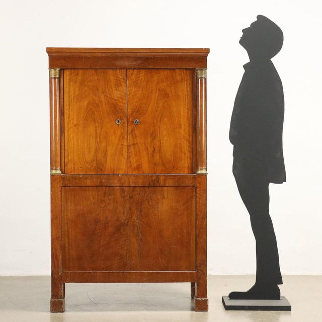 Chest veneered in walnut pedules with 2 doors on the front concealing small drawers and a compartment with flap access...