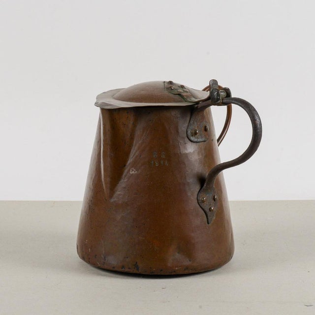 This copper jug, also used as a milk jug, with a lid and two handles is a charming vintage piece, characterized by...