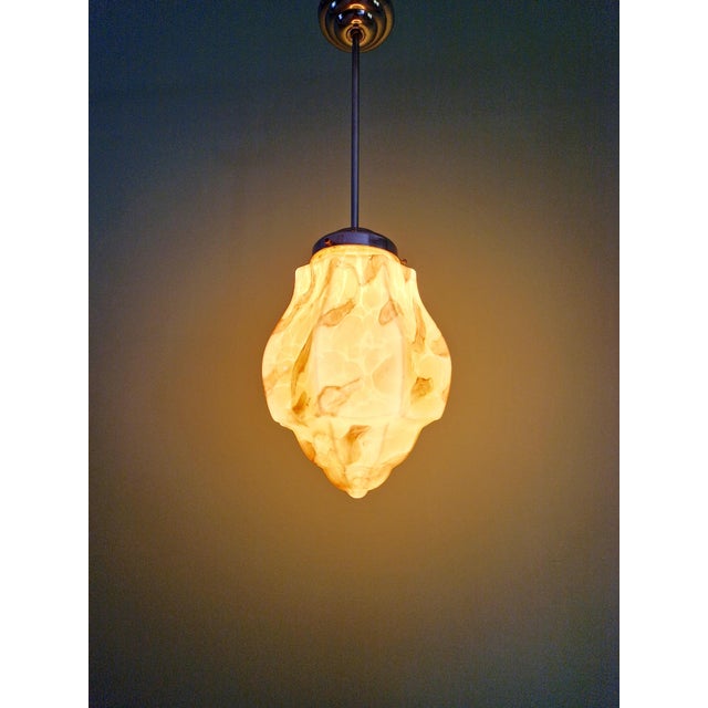 Art deco pendant light in marbled opaline glass (yellow/brown/burgundy tones) with a chromed metal frame, produced at the...