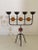 Wonderful piece consists of a metal black base with four arms and orange and red glass inlay. Normal wear consistent with...