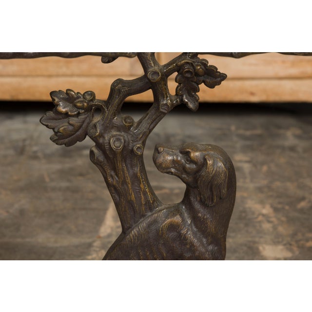 An English iron umbrella stand from the 20th century with dog sitting in front of a tree motif. Add a dash of whimsical...