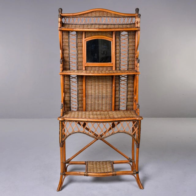 Found in England, this circa 1940s wicker and rattan hall stand has three main shelves on the top portion, a lower shelf...