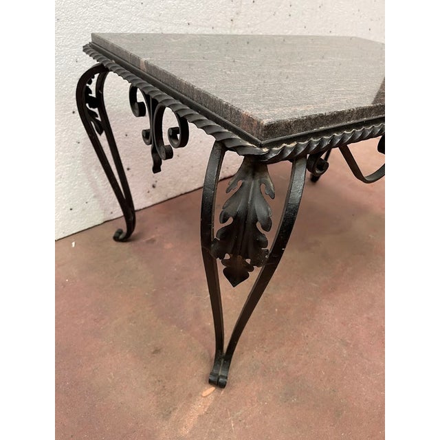 Coffee table with a black patina Wrought iron base with scrollwork decoration Four cabriole legs Breccia marble top Good...