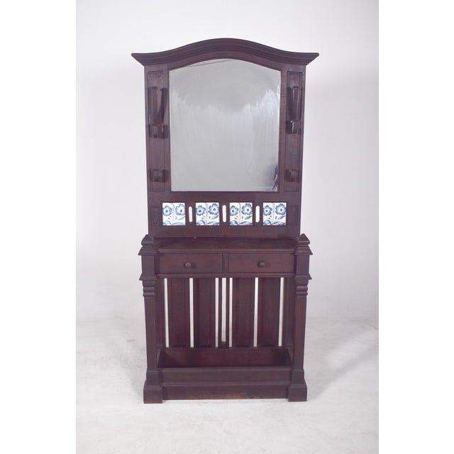 Coat rack with tiles and mirror. Made from solid dark wood, the cabinet is vertically structured, with a sturdy base and a...