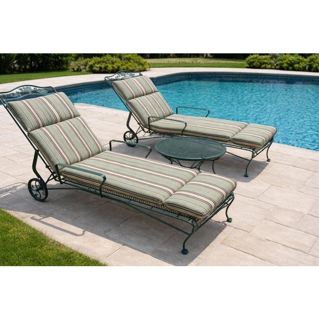 An exceptional pair of Russell Woodard wrought iron chaise lounges featuring the iconic sculpted mesh design and floral...