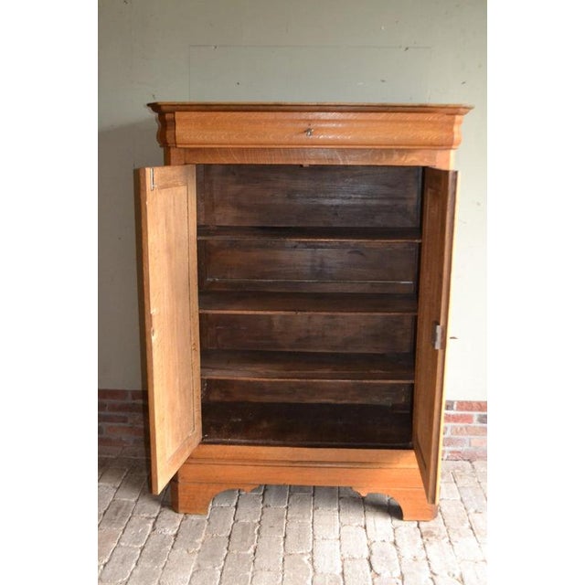 of a 19th-century French oak maid's cupboard. The height is 162 cm. The width is 117 cm. The depth is 51 cm. A drawer at...