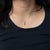 A 0.48-carat oval padparadscha sapphire glows at the centre of this solid 14K white gold pendant, surrounded by twenty-six...