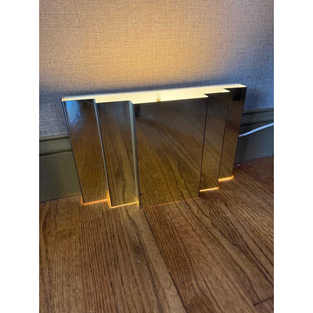 Postmodern vintage polished brass tiered plug-in wall light that cascades light beautifully from the top and bottom when on.