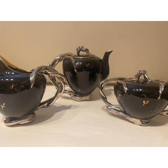 Vintage black and gold hand fired demitasse set. Set includes coffee pot with lid, sugar bowl with lid, creamer, 5 cups...