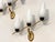 3 1960s wall sconces, gilt brass frame, black lacquered metal and white opal glass diffusers. This piece is designed in...