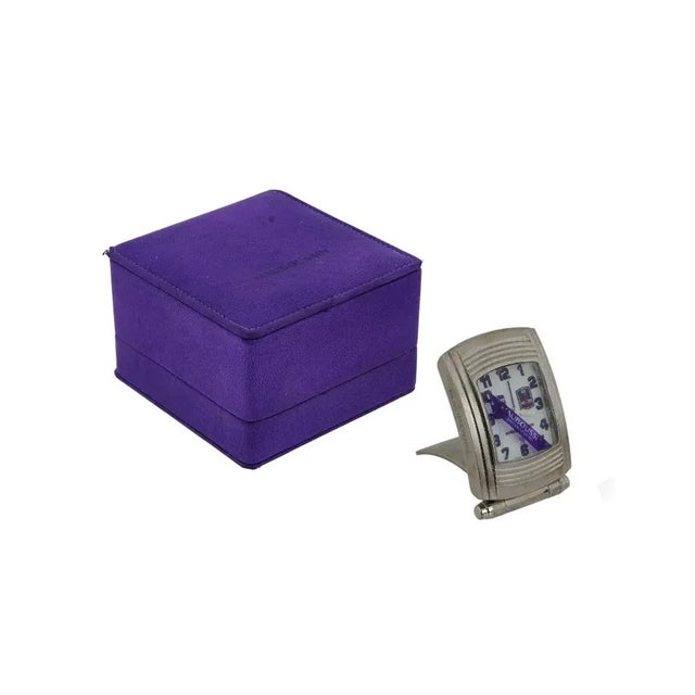 A vintage alarm travel clock by Mauboussin, a French luxury brand. Fouga series. Stainless steel case with single crown....