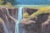 Idealized landscape painting with a waterfall and mountains fading into the distance. The work is signed by the artist in...