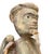An antique Burmese shaman sculpture from the late 1800s, resting on a square base, is depicted standing with a staff in...