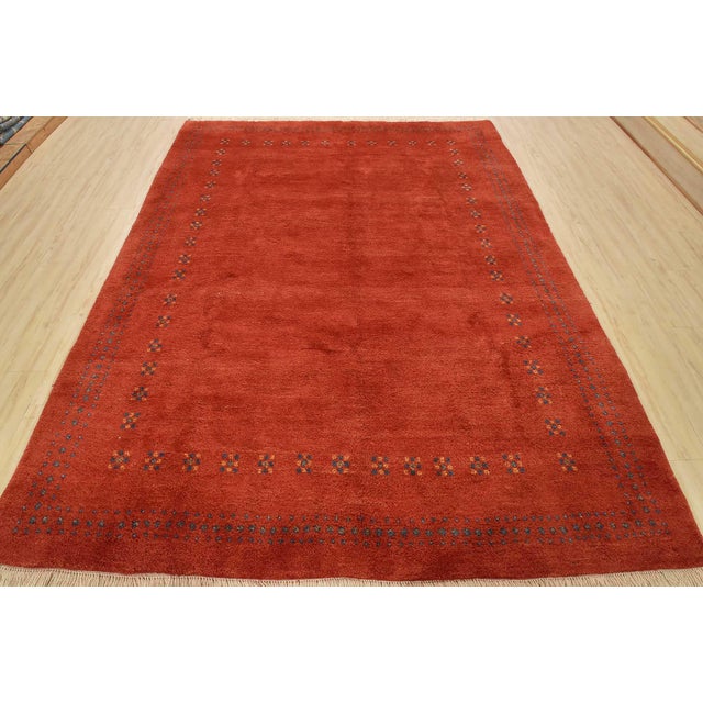 An authentic vintage tribal Gabbeh rug, hand-knotted with fine wool and natural dyes. This nomadic rug features a plush...