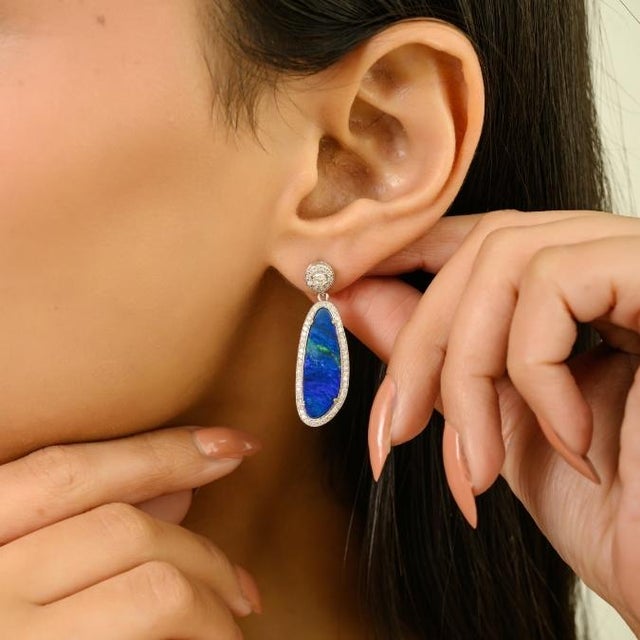 These elegant statement earrings feature 2 uneven vibrant natural fire totaling 6.39 carats, beautifully crafted in 14K...