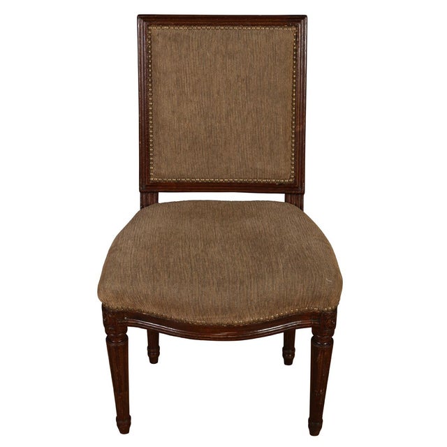 A set of four Louis XVI style square back dining chairs with carved frame, turned and tapered legs, nail head detail to...
