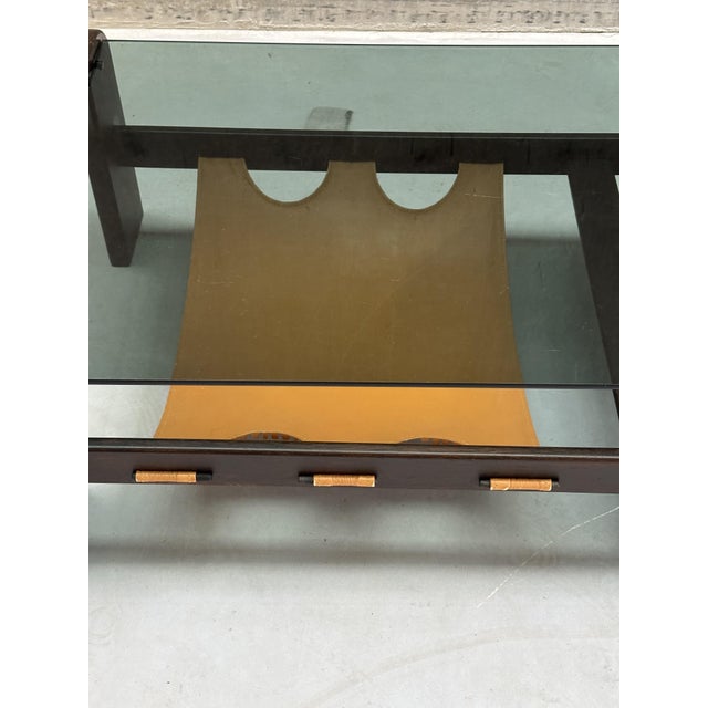 Wengé frame with a cognac-yellow-brown leather magazine holder and a smoked glass top. The table features a sturdy piece...