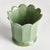 In a classic silhouette with petal edges, this footed pot is natureinspired. Finished in a soft verdant reactive glaze, it...